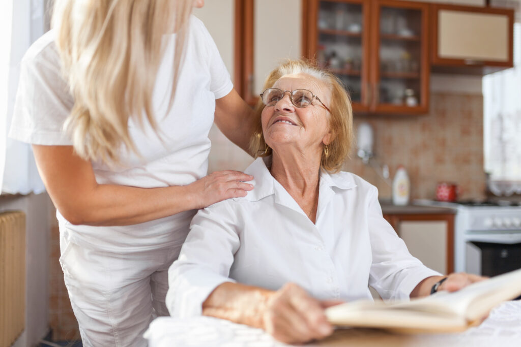 elderly woman smiling at her caregiver
